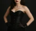 Model wearing a black corset costume with gothic accessories for a Halloween-inspired look.